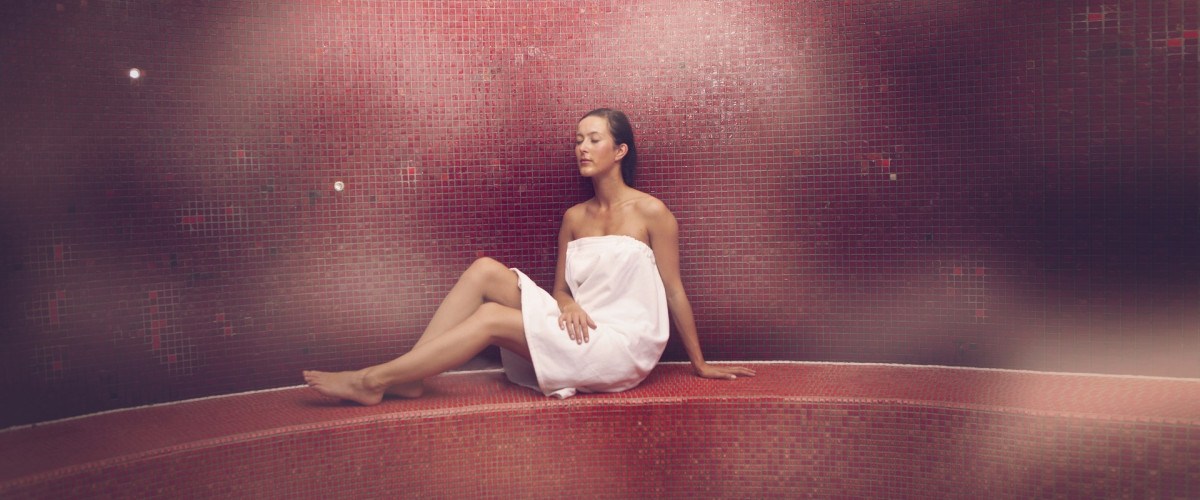 Een vrouw ontspant in de stoomruimte van Thermen Holiday 